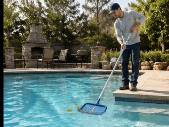 Technician skimming debris from a clear pool